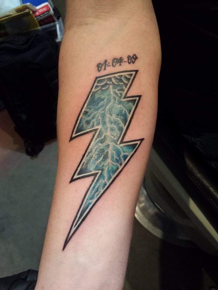 Colour lightning bolt tattoo on a forearm