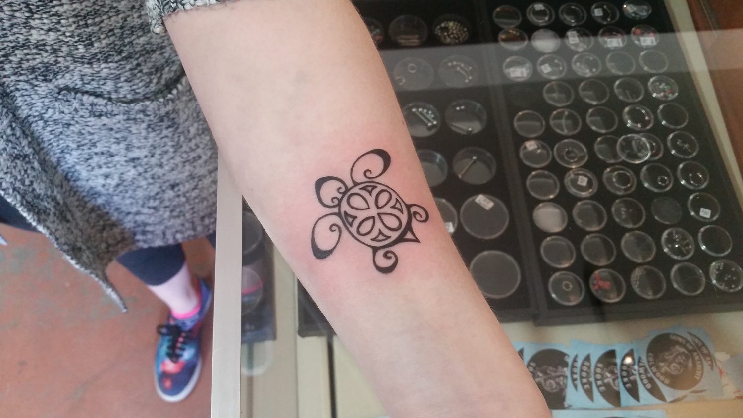 Small black tribal turtle tattoo on an ankle